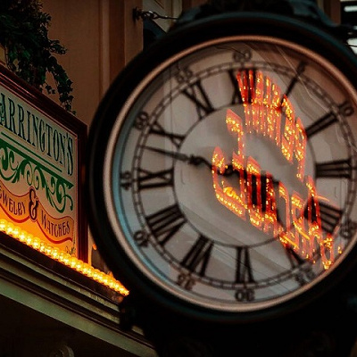 時計に反射するペニーアーケードの看板