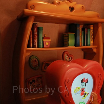 ぬりえマシンの裏には、思い出の写真や本が。ミニーはどんな本を読むのでしょうか？