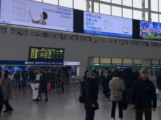 駅の券売所に並ぶ人々